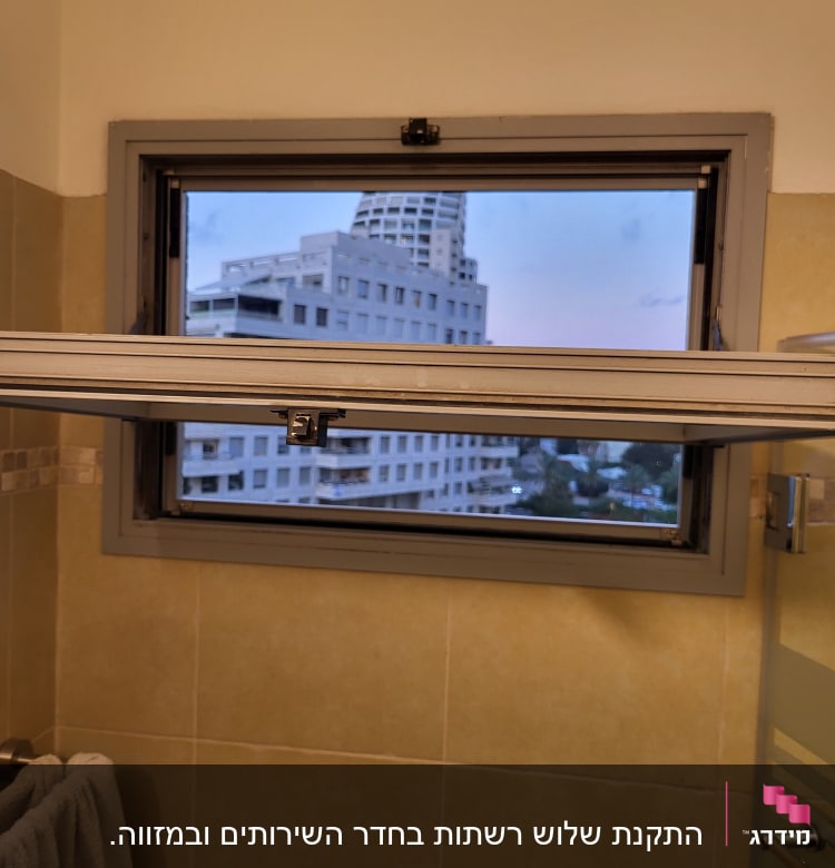 חלון אלומיניום פתוח עם מסגרת אפורה